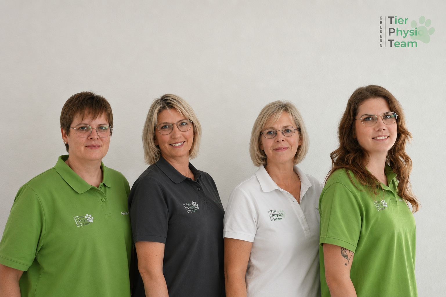 Vierköpfiges Team von Tier Physio Team Geldern in grünen, schwarzen und weißen Polo-Shirts